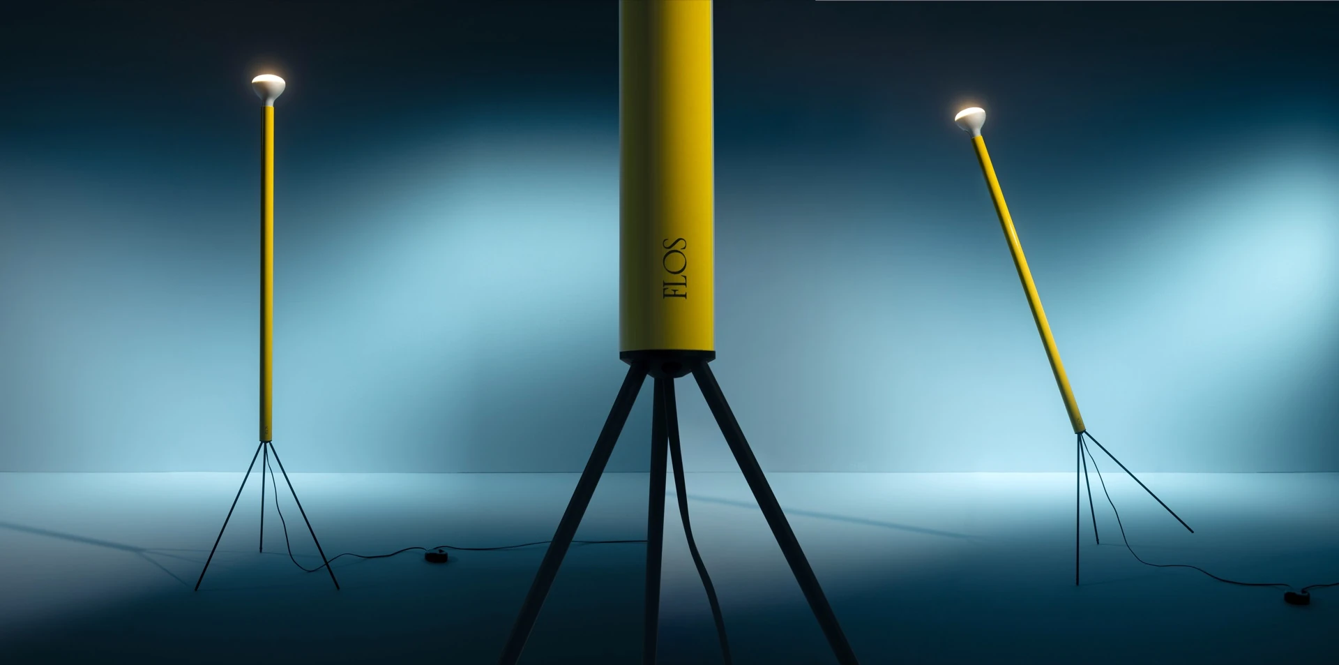 Flos yellow cylindrical floor lamps against a teal studio backdrop