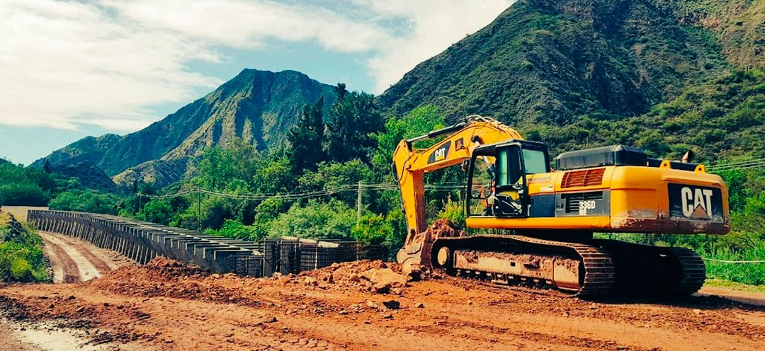 Paolini bridge works — CAT excavator at concrete structure construction in mountains